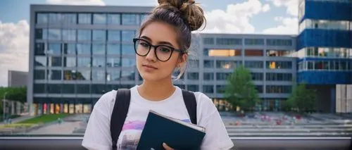 Female college student, double major, architecture and interior design, 20s, casual wear, ripped jeans, white graphic t-shirt, black framed glasses, messy bun, holding a large portfolio, standing in f