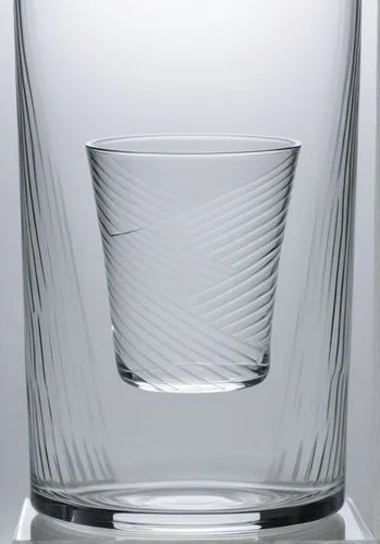 VERRE TRASNPARENT avec lignes graphiques très creusées dans la masse et marqués sur les cotés dans le verre comme si il était taillé  BLANC FOND NEUTRE,a clear glass is on a table,cocktail glass,whisk