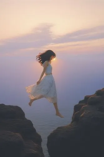 a woman jumping off rocks into the ocean with sun shining,leap for joy,leap,exhilaration,flying girl,weightlessness,leap of faith,gracefulness,exhilaratingly,leaping,floating in the air,falling,jumpin