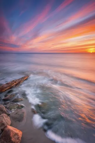 Describe a serene sunset over the sea.,seascape,sunset cliffs,seascapes,coast sunset,coastal landscape,landscape photography,breakwaters,baltic sea,sunrise beach,rocky coast,sea landscape,laguna beach