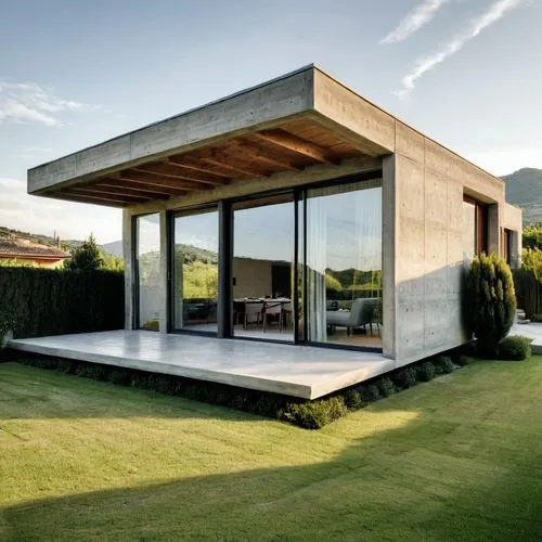 It is a modern single-story house of about 100 square meters, with large open windows at the front, exposed concrete-finished walls, and grassed grounds in the front yard,cubic house,cube house,modern