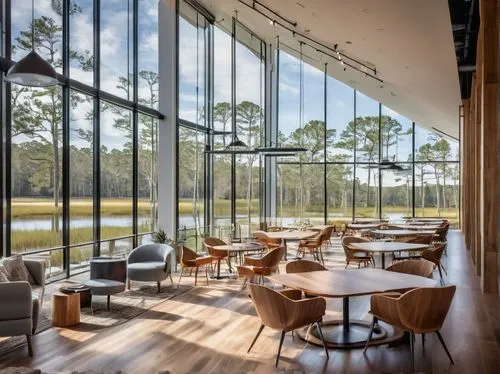 Modern architectural firm, glass and steel building, sleek lines, minimalist decor, large windows overlooking Bluffton's marsh views, busy interior with designers working on computers, blueprints scat