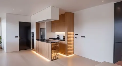 cocina pequeña minimalista, acabados en madera y cubierta en marmol negro, cafetera, copas de vino y estufa de inducción, iluminación indirecta, se debe ver el comedor y la sala
,the wooden kitchen is