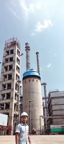 man in front of a plant with a helmet on,thermal power plant,bhagiratha,lignite power plant,batching plant,desulfurization,refractories