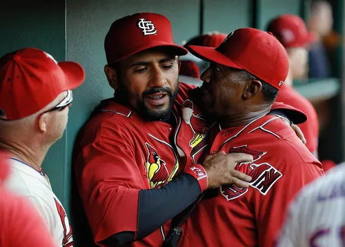 The Cardinals' Jose Martinez (left) hugs assistant coach Willie McGee in the dugout during the seventh inning against the New York Mets on Saturday at Busch Stadium. Photo: Scott Kane / Associated Pre