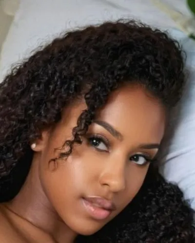 Es ella.. es hermosa ,a black woman wearing gold earrings lies down on a bed,eritrean,ethiopian girl,angolan,thahane,eritreans,ayanda