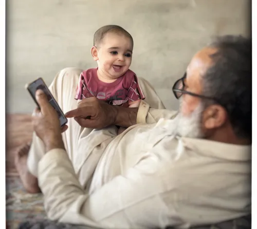 father with child,photographing children,grandchild,granddaughter,little girl reading,father's love,next generation,photos of children,muhammad,kabir,middle eastern monk,holding ipad,sheikh,pediatrics