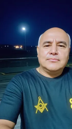 a bald man wearing a t - shirt in a parking lot,incirlik,zahran,mushahid,beitar,sepahan,irbil,arbil,bahria,udeid,mansouri,khursheed,achakzai,abelardo,dimona,fadi,coronel,baghdad,abazi,israir,hamadeh,P