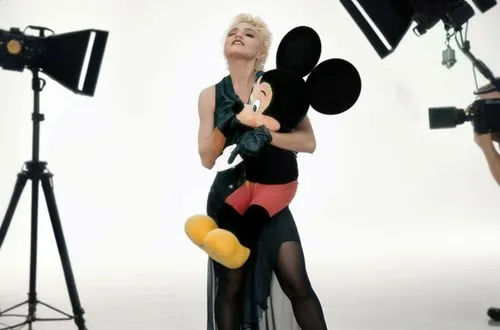 a lady posing for a picture with a mickey mouse stuffed animal,videophone,videoclips,video clip,smilers,miley,madonna