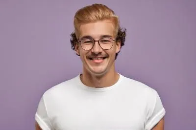 a man with glasses and a white shirt smiles,zarembski,rongjuan,harrynytimes,estern,nerfu,subbaraman,Male,Eastern Europeans,Curly Shag,Teenager,S,Happy,Soccer Jersey,Pure Color,Purple