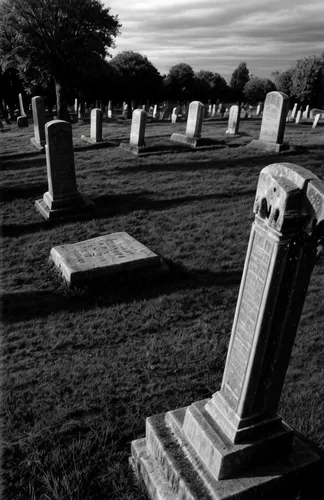 A creepy, spooky ancient cemetery at twilight, a ghostly figure is seen amongst the weathered tombstones. Infra-red style.,grave stones,burial ground,graveyard,gravestones,tombstones,resting place,old