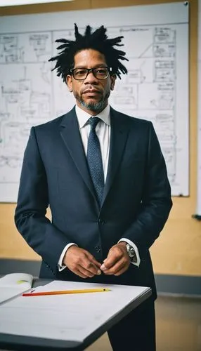 Architectural elements, modern building, Andrew S Gibbons, instructional design expert, middle-aged man, glasses, black hair, beard, formal wear, suit, tie, holding a book, standing in front of a whit