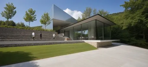 EXTERIOR DESIGN OF A DINING ROOM, LOCATED AT THE BACK OF AN INDUSTRIAL WAREHOUSE, BUILT WITH CONCRETE WALLS AND METAL ROOF, THE DINING ROOM HAS A SET OF STAGGERED STONE WALLS, A STAIR TO REACH THE LOW