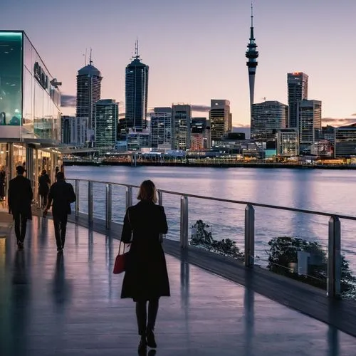 Auckland Film Festival venue, modern architecture, glass building, sleek lines, urban landscape, cityscape, evening atmosphere, warm lighting, people walking in, casual dress, holding tickets, excited