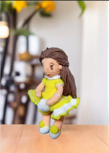 a doll made out of yarn sitting on top of a table,handmade doll,vax figure,doll figure,clay doll,cloth doll,painter doll