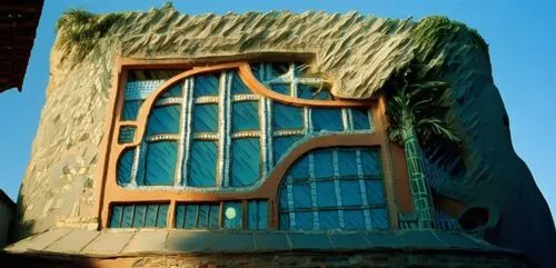 a green building with a brown and blue window and door,gaudi,crooked house,hundertwasser,insect house,cubic house,cube house,Photography,Documentary Photography,Documentary Photography 15