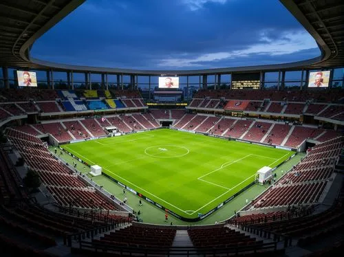 Luminous soccer stadium, tiered seating, lush green grass, goalposts, scoreboard displays, floodlights, evening atmosphere, soft warm lighting, shallow depth of field, 3/4 composition, panoramic view,