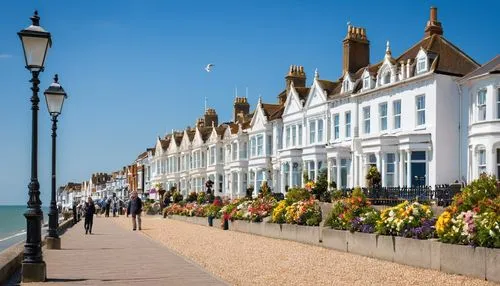 Bognor Regis seaside town, British architectural style, white stone buildings, intricate stonework, ornate facades, Victorian-era details, seagulls flying overhead, beachside promenade, iron railings,