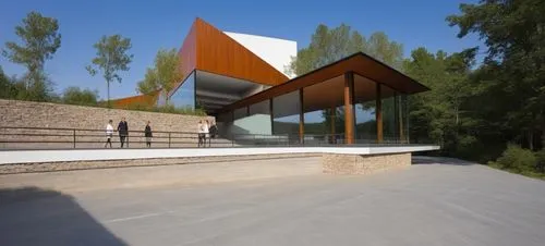 DISEÑO EXTERIOR DE UN COMEDOR, UBICADO EN LA PARTE POSTERIOR DE UNA NAVE INDSUTRIAL, CONSTRUIDA CON MUROS DE CONCRETO Y TECHUMBRE DE LAMINA, EL COMEDOR CUENTA CON UNA CONJUNTO DE MUROS DE PIEDRA ESCAL