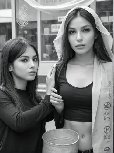 Black and white photo without symbols and signs. The girls tenderly worship and caress something.,two women standing in front of a store next to each other,mexicanas,chicanas,cholas,modelos,peruvians,