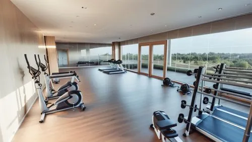 equipped gym, bright, white walls, ceiling lights, parquet on the floor, glass parapets, no windows.
modern style.
,an empty exercise gym with windows on the wall,fitness room,fitness center,fitness f