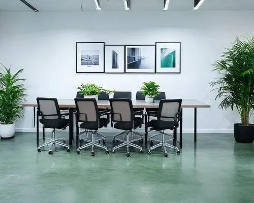 Créez une photo lifestyle, pour un site e-commerce, une salle de réunion lumineuse, une table de réunion, des ordinateurs, une plante verte et un sol en béton lissé,there is an office meeting room wit