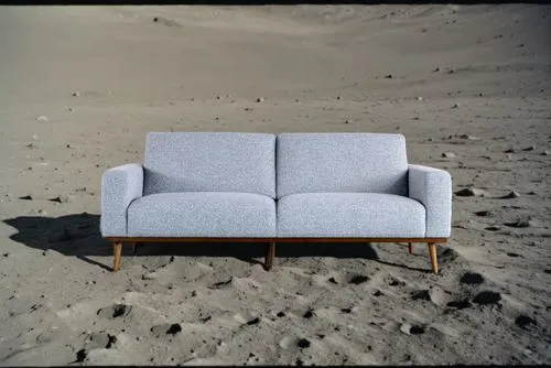 on the surface of the moon,a blue sofa sits on sand dunes at the edge of an ocean,beach furniture,natuzzi,loveseat,soft furniture,cassina,sofa