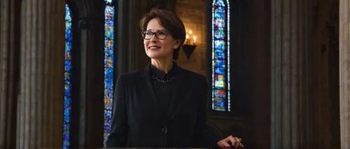 Modern ethics professor, mature lady, (40yo), short brown hair, glasses, elegant smile, white blouse, black pantsuit, heels, standing, lecturing, university campus, Gothic architecture building, stone