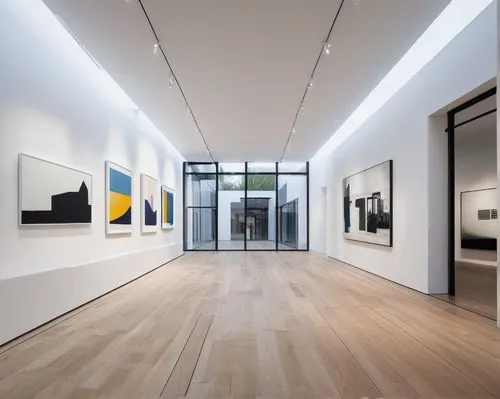 Modern art gallery, white cube-shaped building, geometric structure, glass facade, minimalist entrance, wooden floors, high ceilings, track lighting, white walls, abstract sculptures, contemporary pai