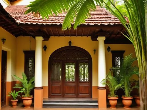 Traditional Kerala style architecture, sloping roof, terra cotta tiles, intricately carved wooden doors, large windows with ornate shutters, ornamental columns, grand entrance, spacious veranda, curve