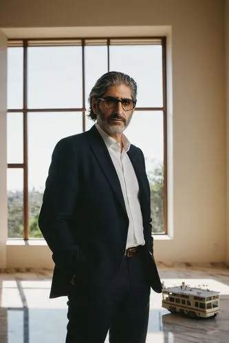 Michael Imperioli, mature man, 50yo, beard, glasses, balding hair, suits, white shirt, tie, holding architectural model, standing, indoor, modern villa, large windows, minimalist decor, marble floor, 