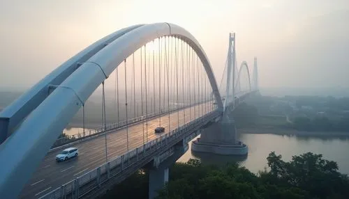 Elegant vehicular bridge, sleek modern design, silver metallic surfaces, subtle curves, minimalist railings, LED lighting systems, misty morning atmosphere, soft warm glow, shallow depth of field, 1/1