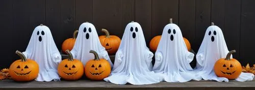 a number of fake pumpkins next to two ghost heads,halloween ghosts,halloween background,halloween decoration,haloween,halloween decor,halloweenkuerbis