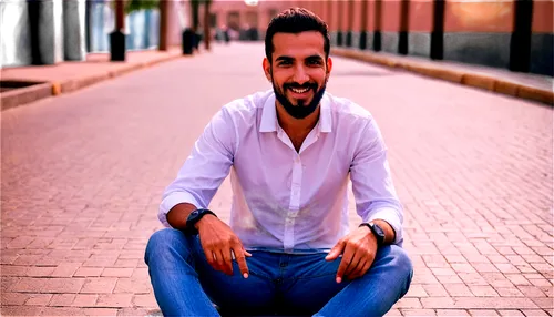 Mohamed Hassan, male, Arab, 30s, beard, mustache, dark hair, brown eyes, smiling, casual wear, white shirt, blue jeans, sneakers, sitting, relaxed pose, urban background, soft natural light, warm colo