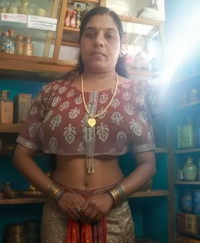 a woman wearing a necklace and holding two sari sari,sivakami,rajalakshmi,shailaja,jayalakshmi,srividya,manorama