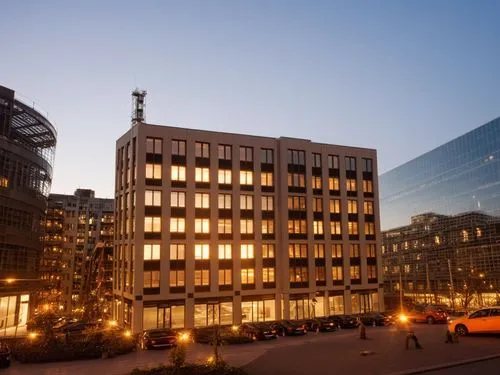 a bustling office building stretches from the smallest of buildings in the bustling city. The buildings are sleek and modern, with high ceilings and ornate clocks in sight. Passersby sit in the window