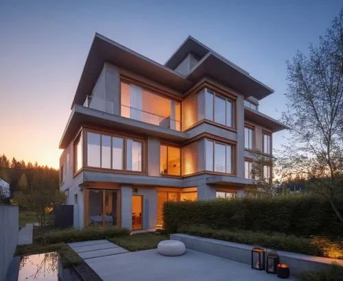 an unusual building is lit up at dusk,modern house,modern architecture,homebuilding,architektur,lohaus,cubic house