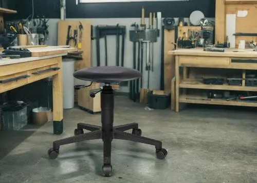 Une photo d'un atelier de bricolage 
moderne bien agencé avec une table de travail avec les outillages et ce tabouret d'atelier. Pas d'objets en bois,a black office chair sitting on top of a hard wood