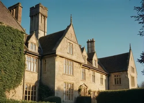 Hertfordshire, English countryside, grand villa, architectural design, luxurious mansion, cream-colored stone walls, tall chimney, steeply pitched roofs, multi-paned windows, ornate doorways, ivy-cove