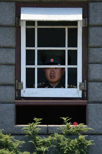 A North Korean soldier looks through a window at Secretary of State Hillary Rodham Clinton while she visits the U.N. truce building in Panmunjom village in the demilitarized zone that separates the tw