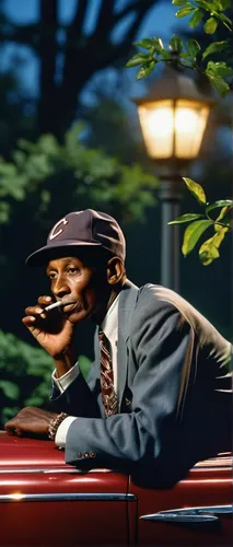 Baseball player Satchel Paige, looking dapper, lighting his cigarette while sitting on front bumper of large car.  (Photo by George Strock/The LIFE Picture Collection/Getty Images),black businessman,j