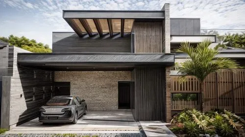 woody slatted dark color, black elements, wall in natural stone cut in the shape of a brick, wall on the left in slatted in burnt cement, floors in satin porcelain tiles with thin joints, door with ha