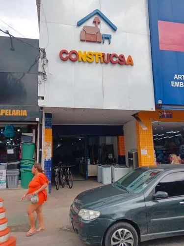 an orange shirted woman and a green car in front of a building,cascavel,costa rican colon,commericial,coatzacoalcos,conaculta,corozal