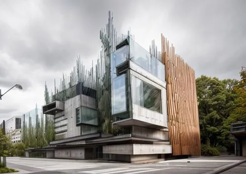 A building made of contreate and glass, located at an intersection with residential buildings around it, in rainy weather,glass facade,modern architecture,glass facades,christ chapel,kirrarchitecture,