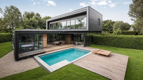 modern farmhouse villa . juxtapositioned cube . wooden deck with outdoor seating near swimming pool. living and dinning room with large glass doors seperating indoor and outdoor. landscape with gravel