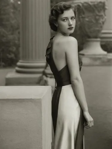 A lady from the 1940s in front of a classical column.,an old po of a woman standing by some pillars,ziegfeld,jane russell-female,ingrid bergman,stanwyck,olivia de havilland,hayworth,Photography,Black 