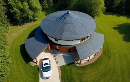 Мodern house surrounded by a forest.
The walls are white. Black roof.,an aerial view shows the large pavilion, surrounded by lush green grass,round barn,pilgrimage church of wies,dovecote,bird's-eye v