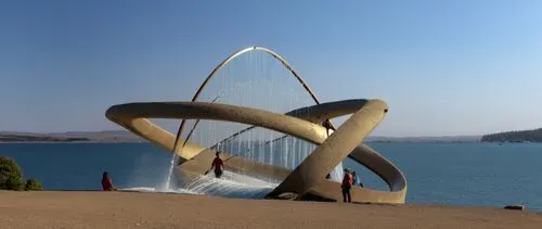 A hyperrealistic sculpture concept featuring interlocking circles. Inside the circles, there are people walking, and the largest arch contains a waterfall cascading down. At the base inside the sculpt