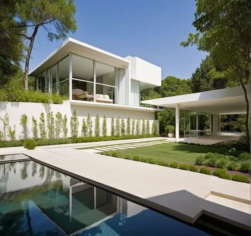 DISEÑO ESTERIOR DEL ACCESO A UNA RESIDENCIA, CON UN PORTON METALICO EN INMITACIÓN MADERA, CON PLANTAS DE FORMIO EN EL ACCESO, ARBOLES Y VEGETACIÓN EXUBERANTE,there is a house that is overlooking the p