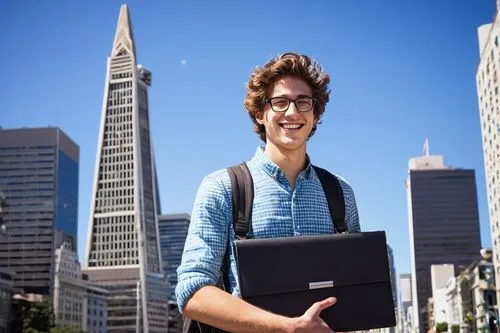 Modern young adult, male, intern, (20yo), casual wear, glasses, messy brown hair, smiling face, holding a large portfolio case, standing in front of a San Francisco skyscraper, The Transamerica Pyrami